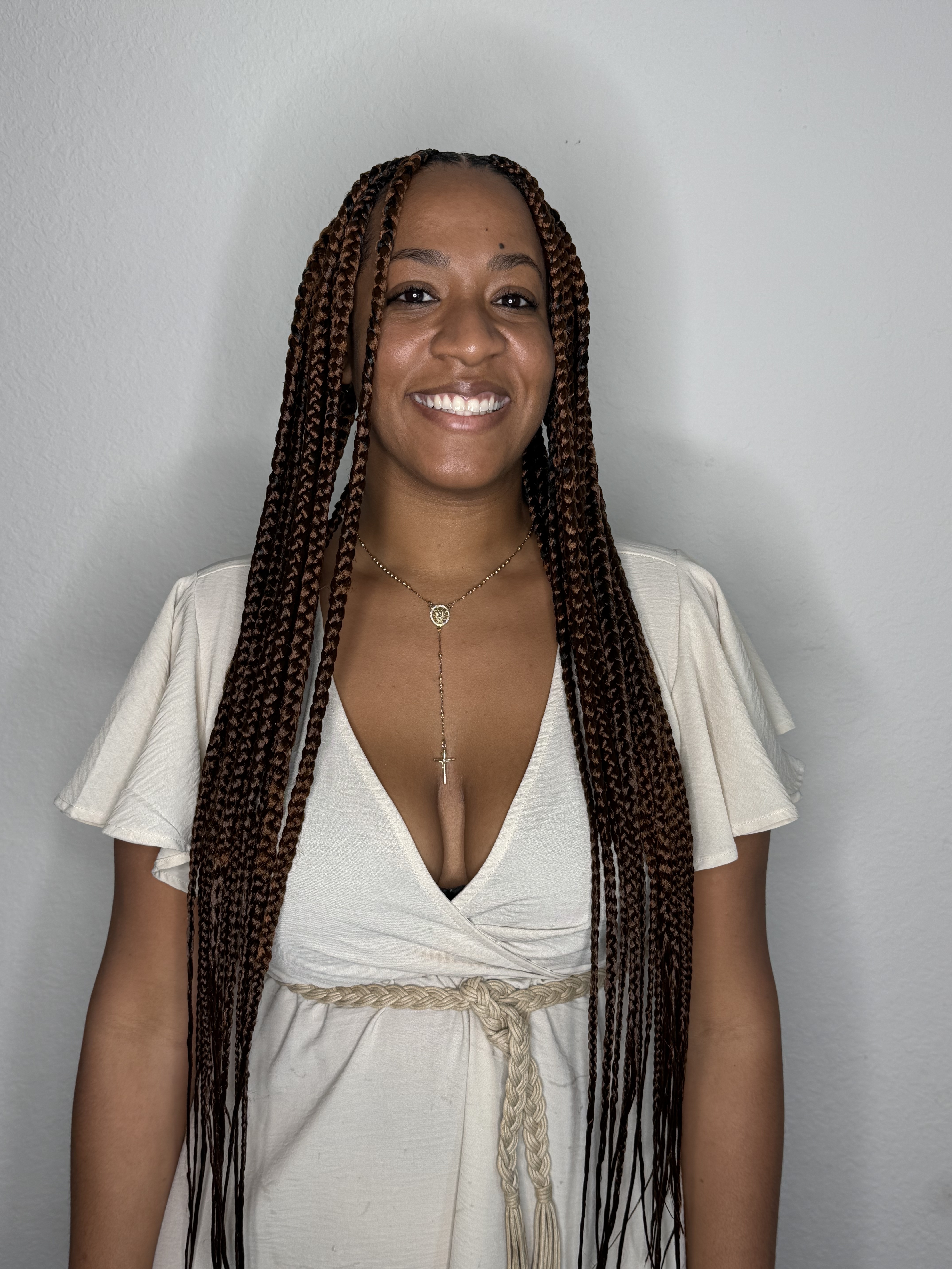 Smiling client with long braids styled by Yulis